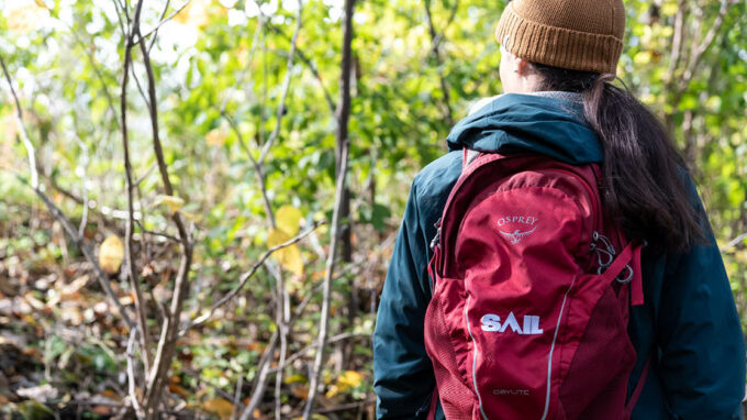 Woman in the forest with a SAIL backpack