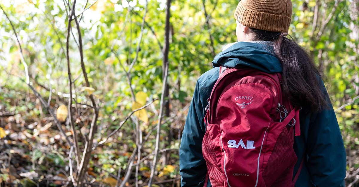 Woman in the forest with a SAIL backpack