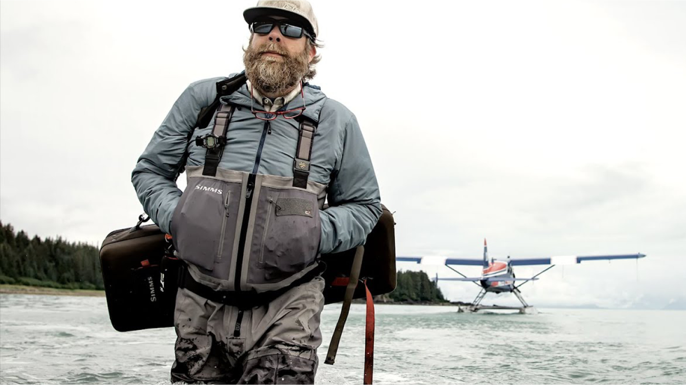 Homme portant des cuissardes et vêtements de pêche bord de lac