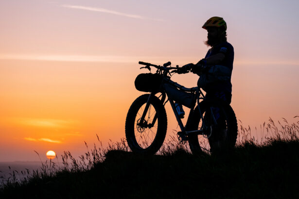 Homme avec un fat bike devant un coucher de soleil
