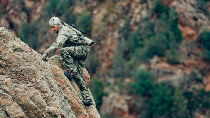 Hunter climbing a rock with hunting boots