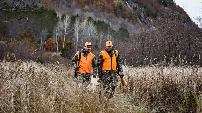 Two hunters dressed for moose hunting in the wild