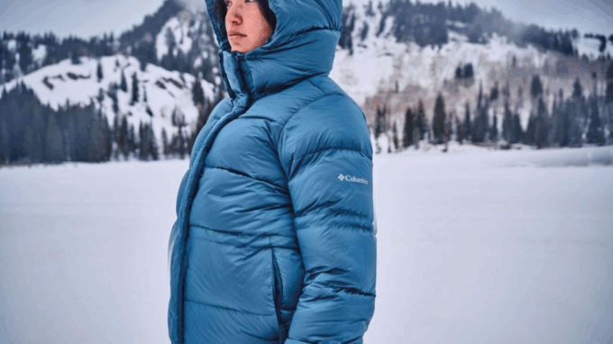 Person wearing a blue Columbia winter jacket in a snowy mountain setting.