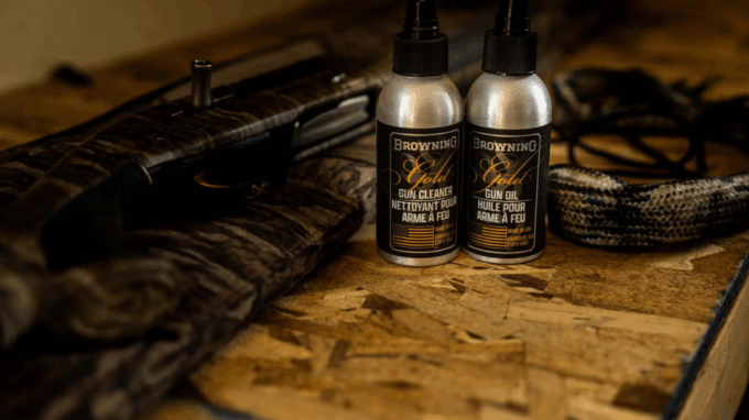 Arme à feu de chasse entourée de produits et outils d'entretien Browning (nettoyant, huile, bore snake)