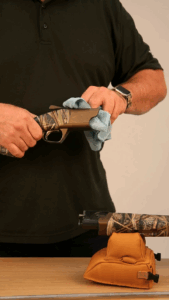 Dégraissage d'une partie d'un fusil de chasse avec un linge doux.