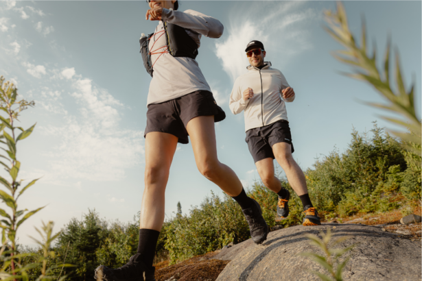 woman and man trail running on rocky terrain in trail running shoes