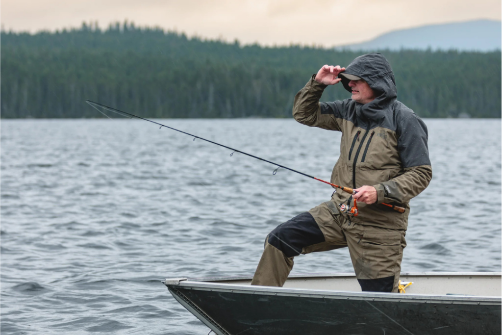 un homme portant des vêtements et accessoires de pêche Sportchief pêche au lancer dans une chaloupe