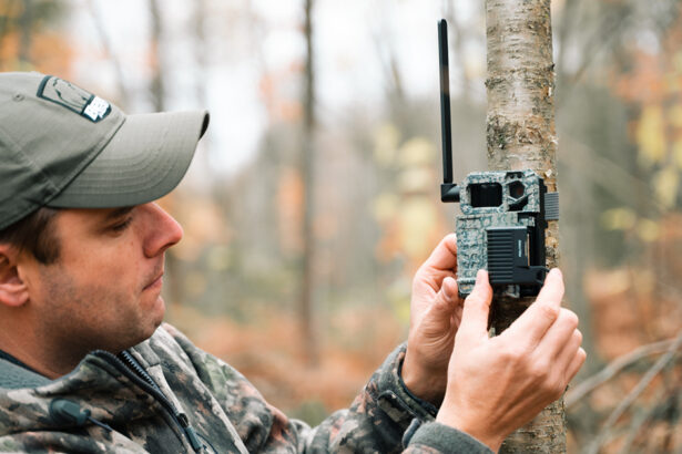 Hunter setting up trail camera to spot white-tailed deer