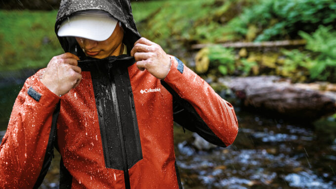 Man hiking in rain wearing Columbia water-repellent jacket