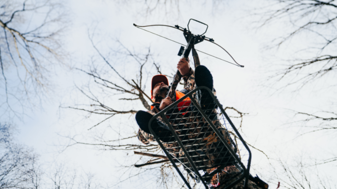 Chasseur dans un mirador lors d’une sortie de chasse à l’arbalète en forêt
