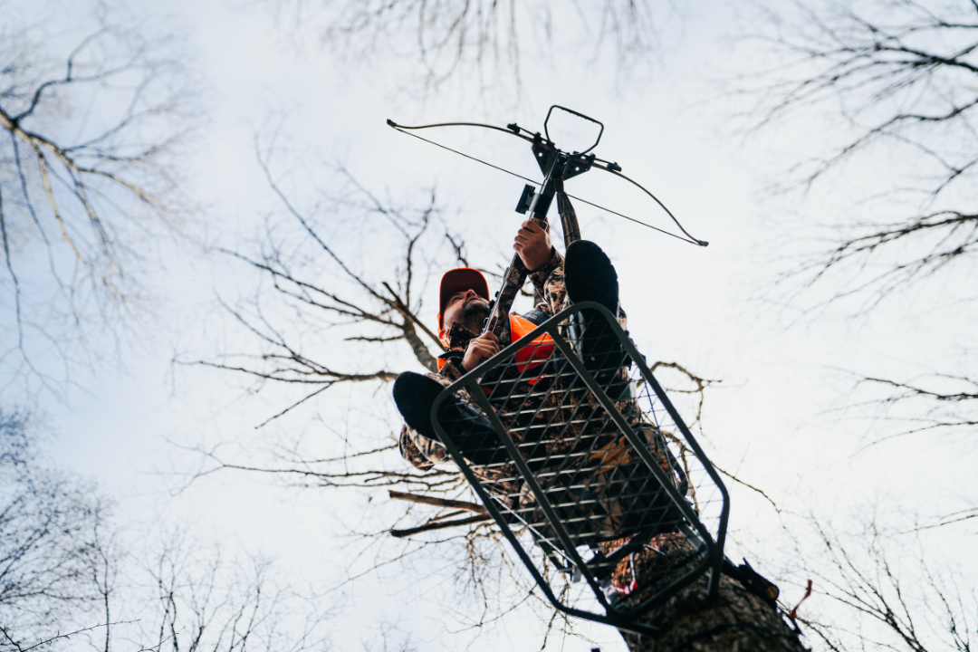 Chasseur dans un mirador lors d’une sortie de chasse à l’arbalète en forêt