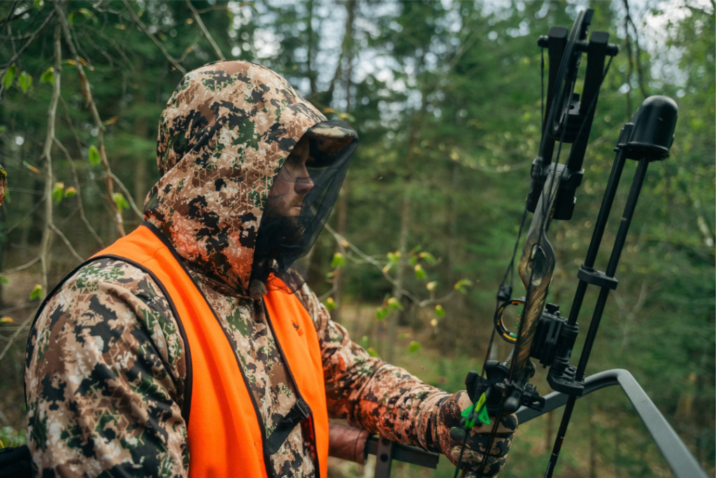 Chasseur en forêt équipé d’une arbalète de chasse et de vêtements de camouflage