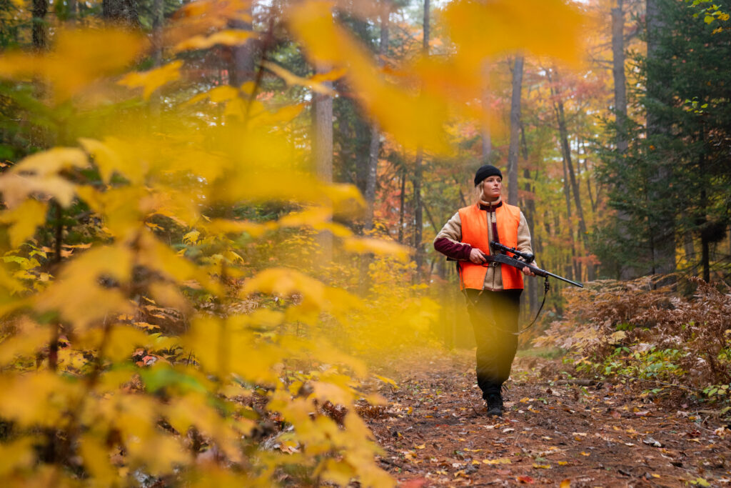 A woman hunting with her orange jacket
